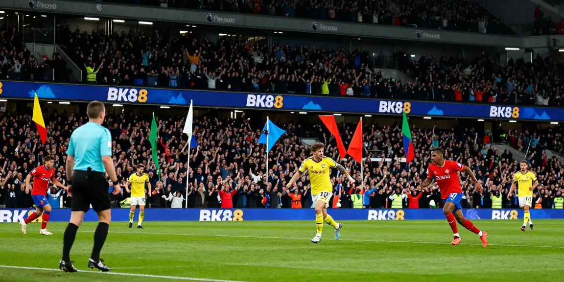 Exciting football match featuring BK8 branding at a vibrant Premier League stadium, showcasing fan enthusiasm and player action.